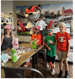 Kids around a table with the Flying Squirrels mascot 