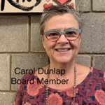 CarolDunlapBoardMember, Caucasian womanwith salt and pepper hair; wearing blue and red rimmed glasses; wearing a red and pink flower blouse; wearinga beaded necklace over blouse