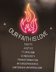 A stylized neon flame with text that reads "OUR FAITH IS LOVE" followed by words like "EQUITY" and "JUSTICE" on a black background.
