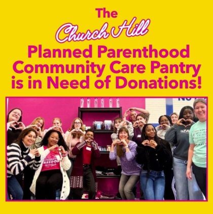A group of people forming heart shapes with their hands in front of a pink wall with shelves.